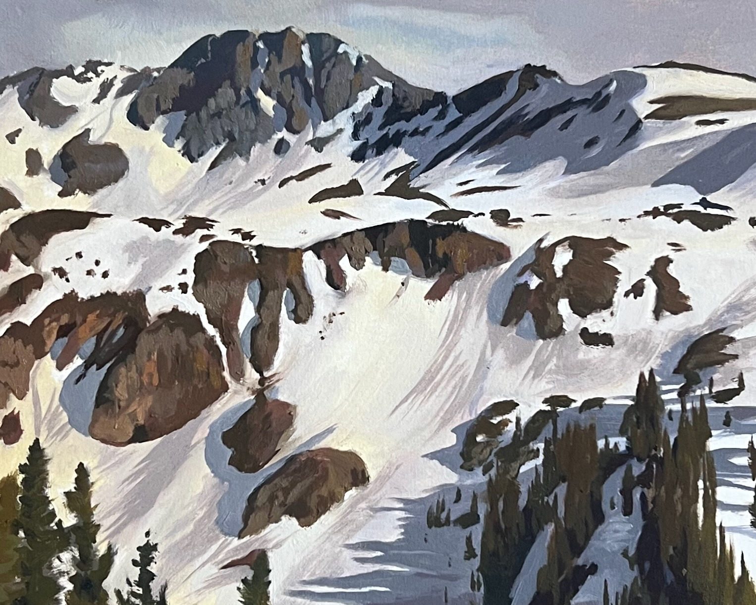 A high basin still deep in snow below dark rocky peaks, with bare brown rock breaking through the drifts and spruce trees along the lower edge.
